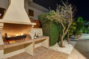 eine Feuerstelle im Freien in einem Garten mit Hecke in der Unterkunft Luxury Coral Bay Villa Villa Shanta 3 Bedroom Villa Distant Sea Views in Peyia