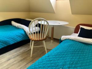 a room with a bed and a chair and a table at Jūrlejas in Kaltene