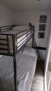 a bunk bed in a room with white sheets at Vakantiepark Klein Strand - Luxe Houten Chalet in Jabbeke