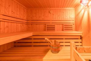 eine leere Holzsauna mit Eimer darin in der Unterkunft Ferienhaus Strandmuschel in Groß Schwansee