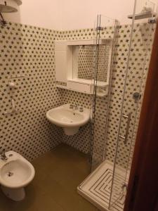 a bathroom with a toilet and a sink and a shower at Casa Vinella in Putignano