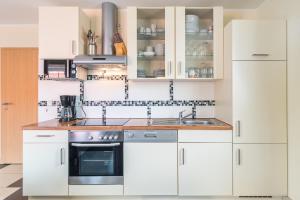 a kitchen with white cabinets and a sink at Ferienwohnung Seeigel in Tarnewitz +32 photos