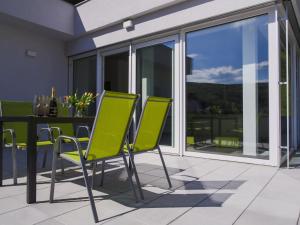 un patio con sillas verdes y una mesa en Villa Irene, en Trenčianske Teplice