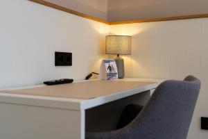 a desk in a room with a chair and a lamp at Hotel Seebrise Grömitz in Grömitz +13 photos