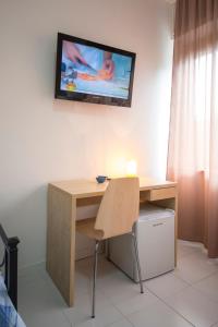 einen Schreibtisch mit einem an der Wand hängenden TV in der Unterkunft Camere Oberdan in Foligno