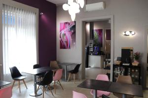 a room with tables and chairs and a painting on the wall at The Originals City - Hôtel Saint-Martial, Limoges Centre in Limoges +73 photos