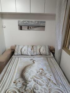 a bed with a painting of a bird on it at Coin paradisien juillet-août min 3 nuits in Meudon