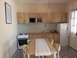 a kitchen with a wooden table with chairs and a refrigerator at Riviera house in Asprovalta