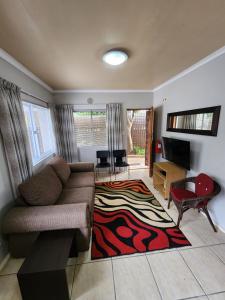 a living room with a couch and a rug at 80 Kendal Guest House in Bellville