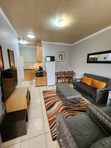 a living room with two couches and a kitchen at 80 Kendal Self-Catering Guest House in Bellville