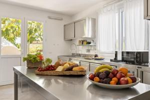 a kitchen with a bowl of fruit on a counter at Villa Ambra 10, Emma Villas in Sorso
