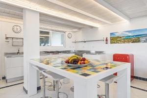 a kitchen with a table with a bowl of fruit on it at Villa Ambra 10, Emma Villas in Sorso +38 photos