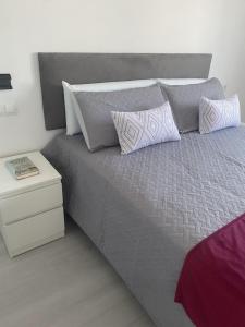 a bed with two pillows and a night stand at LEON 38 Apartments Private Parking - EaW Homes in Estepona