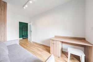 a bedroom with a desk and a chair at Comfort Apartments Batorego in Gdynia