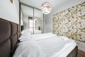 two beds in a room with a wall of mirrors at Comfort Apartments Batorego in Gdynia +46 photos