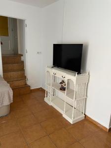 a television on a white stand in a room at Casita esquiladores in Cuenca +3 photos