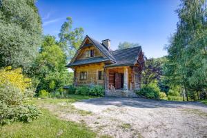 an old house in the woods with a driveway at Domek Łemkowski in Ustrzyki Dolne