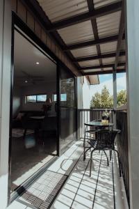 BooragulにあるBright & Modern Booragul Home for Familiesのバルコニーにテーブルと椅子が置かれたパティオ