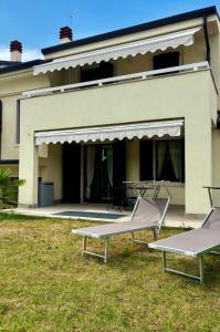 ガルダにあるCà Leo in Garda, relax & poolのラウンジチェア2脚とパティオのある建物
