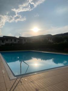 ガルダにあるCà Leo in Garda, relax & poolの夕日を背景にしたプール