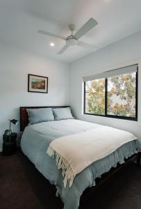 BooragulにあるBright & Modern Booragul Home for Familiesのベッドルーム1室(ベッド1台、シーリングファン付)