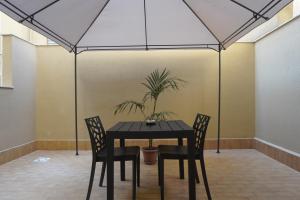 巴勒莫Le Stanze del Massimo的一张带两把椅子的黑桌和一盆盆盆栽