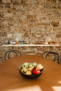 un cesto di frutta seduto su un tavolo di legno di Casale Santa Rosalia Charme Villas and Rooms a San Mauro Cilento Altre 53 foto