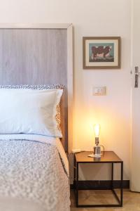 a bedroom with a bed and a table with a lamp at Casa Alderotti in Bologna