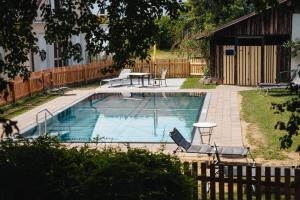 a swimming pool with a table and chairs next to a house at Gasthof Pension Rabl in Völkermarkt