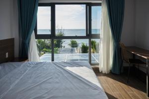 a bedroom with a bed and a view of the ocean at Sea Sand Garden Villa in Phan Thiet +17 photos