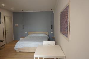 巴勒莫Le Stanze del Massimo的一间带床和桌子的白色卧室