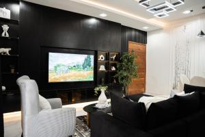a living room with black walls and a flat screen tv at Brand New 2bed flat close to the beach with 2 balconies in Lekki