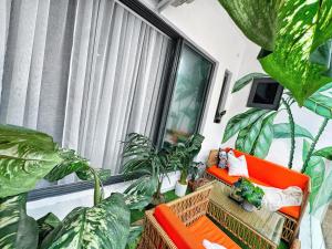 a living room with plants and an orange couch at Brand New 2bed flat close to the beach with 2 balconies in Lekki
