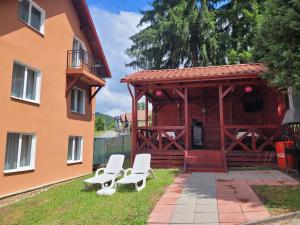 Dos sillas blancas frente a un edificio. en La Flori, en Sovata