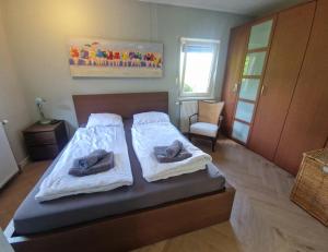 een slaapkamer met een bed met handdoeken erop bij Holiday house Zeelust - 2 km from the beach in Noordwijkerhout