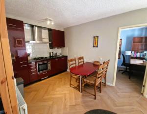 een keuken en eetkamer met een tafel en stoelen bij Holiday house Zeelust - 2 km from the beach in Noordwijkerhout