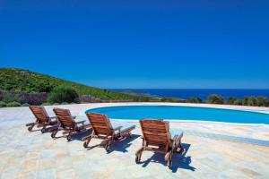 a row of chairs sitting next to a swimming pool at Magnificent Hvar Villa 7 Bedrooms Villa Lambik Beautiful Sea Views & Private Heated Swimming Pool in Hvar