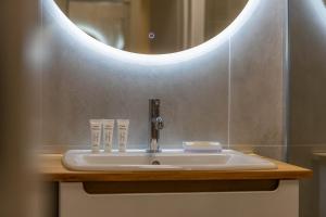 a bathroom sink with a round mirror above it at Miedza Apartament - Targówek, Metro Trocka in Warsaw +15 photos