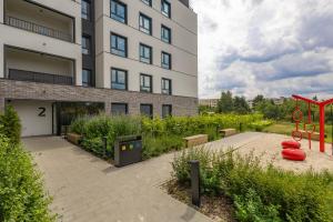 a building with a playground in front of a building at Miedza Apartament - Targówek, Metro Trocka in Warsaw