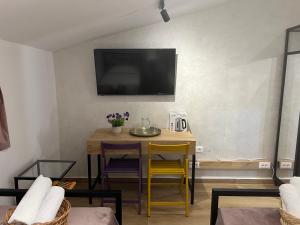 a dining room with a table and a tv on the wall at Doctor's House in Tepelenë