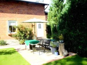 a patio with a table and chairs and an umbrella at One-Bedroom Apartment in Putbus II in Putbus