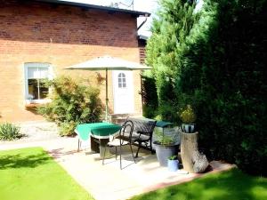 a patio with a table and chairs and an umbrella at One-Bedroom Apartment in Putbus II in Putbus +3 photos