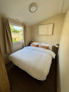 a bedroom with a large white bed and a window at Miarlo Lodge Rydal Haven Lakeland in Flookburgh
