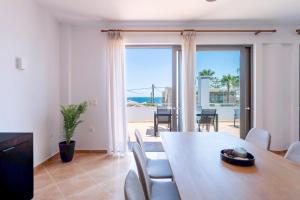 a dining room with a table and a view of the ocean at Kalamaki Del Mar in Chania