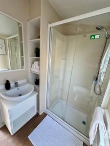 a bathroom with a shower and a sink at Miarlo Lodge Rydal Haven Lakeland in Flookburgh