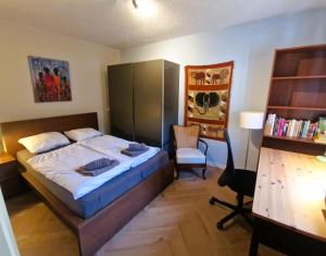 een slaapkamer met een bed, een bureau en een stoel bij Holiday house Zeelust - 2 km from the beach in Noordwijkerhout