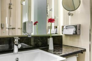 a bathroom with a sink and a mirror at IntercityHotel Bonn City in Bonn