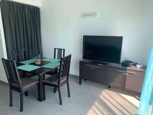 a dining room with a table and a flat screen tv at La Grisot de la mer Saint Hilaire in Saint-Hilaire-de-Riez