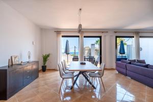 a living room with a table and a purple couch at Kalamaki Del Mar in Chania +16 photos