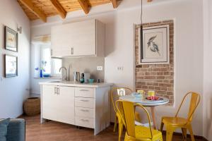 a kitchen with a small table and yellow chairs at Tobacco House Suites in Corfu
